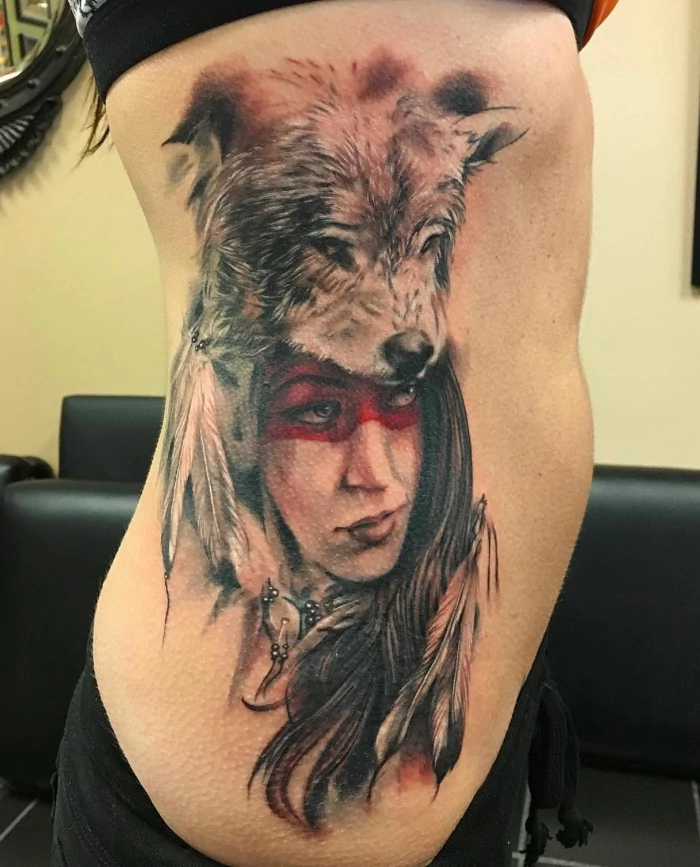 Native american woman with wolf's head costume super realistic portrait side tattoo done in black and grey ink with red mask by tattoo artist Russ Howie of Sacred Mandala Studio in Durham, NC.